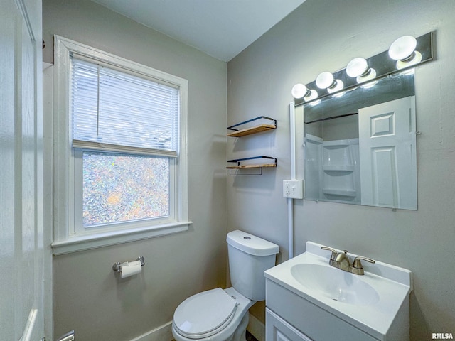 bathroom with a healthy amount of sunlight, vanity, and toilet