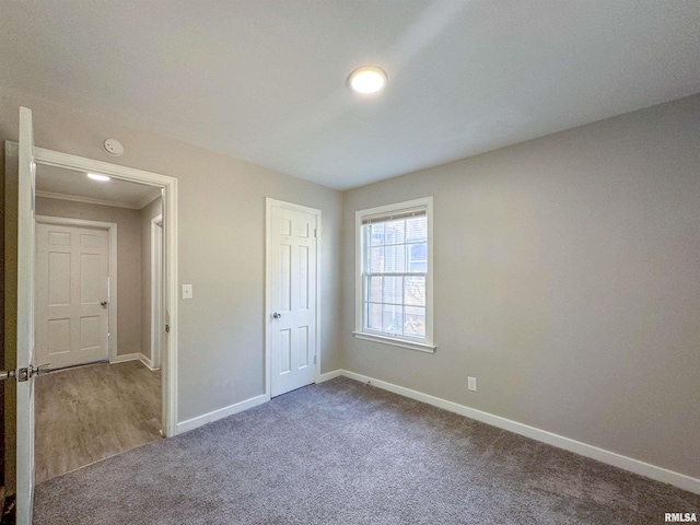 unfurnished bedroom with crown molding and carpet floors