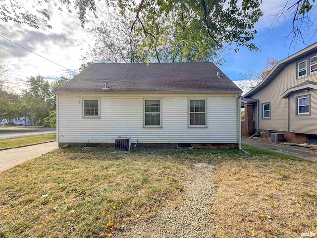 back of property with a yard and central air condition unit