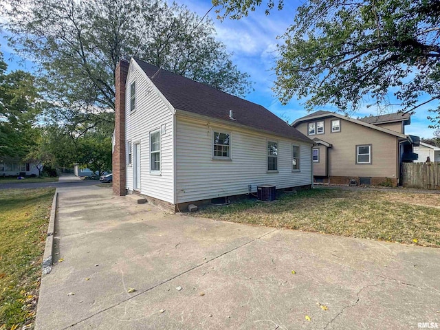 view of front of home with central AC unit and a front lawn