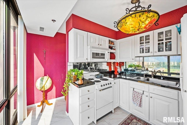 kitchen with white appliances, sink, and white cabinets