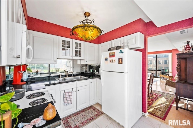 kitchen with white appliances, white cabinetry, sink, and a healthy amount of sunlight