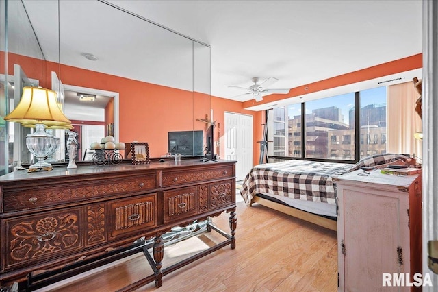 bedroom featuring light hardwood / wood-style floors, ceiling fan, and a closet