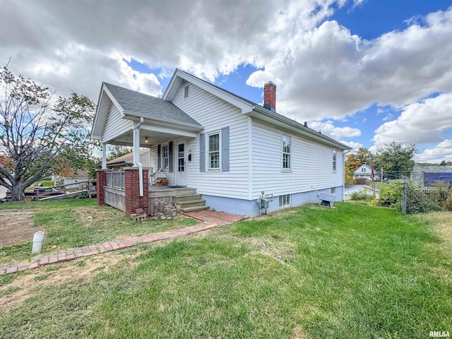 782 N Ave B, Canton, IL 61520 - view of property exterior with a porch, a yard, and a chimney
