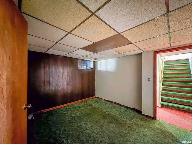 basement featuring a paneled ceiling and carpet flooring