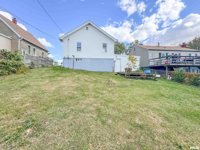 rear view of property with a lawn and a deck