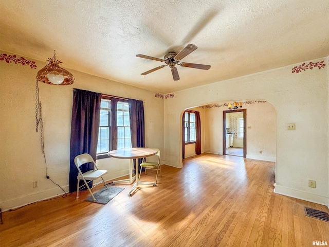 unfurnished room featuring ceiling fan, light hardwood / wood-style floors, and a textured ceiling