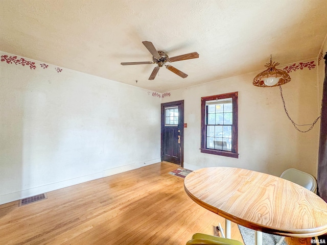 entrance foyer with wood-type flooring, ceiling fan, and a textured ceiling