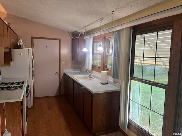 kitchen featuring a textured ceiling, white range with gas stovetop, sink, and dark wood-type flooring