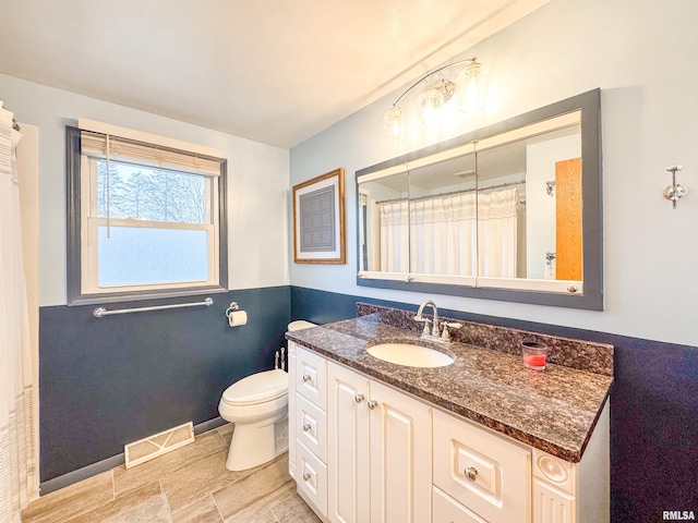 bathroom with vanity, toilet, and curtained shower