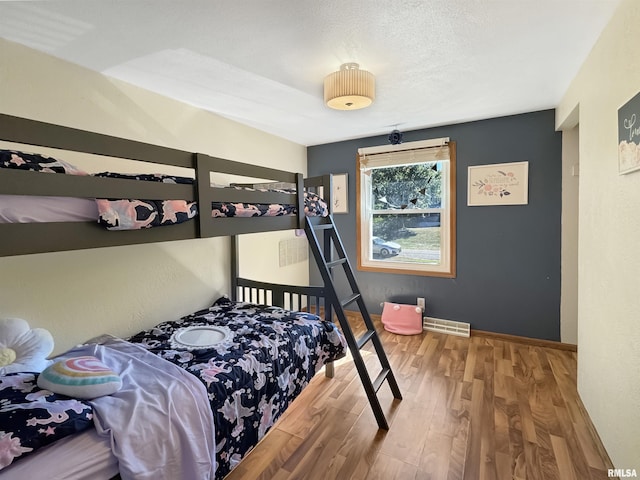 bedroom with hardwood / wood-style flooring and a textured ceiling