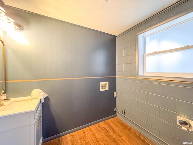 interior space featuring washer hookup, sink, and light hardwood / wood-style flooring