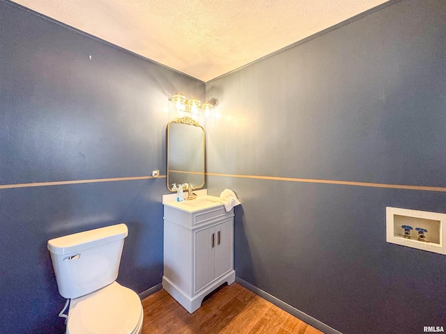 bathroom with a textured ceiling, vanity, hardwood / wood-style flooring, and toilet