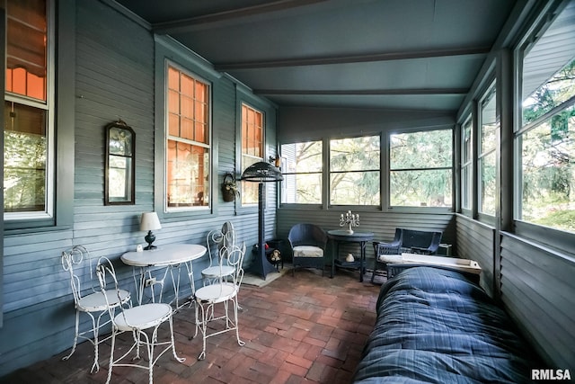 sunroom featuring a wealth of natural light and lofted ceiling with beams