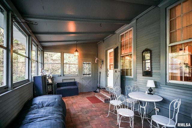 sunroom featuring lofted ceiling with beams