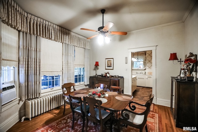 dining area with crown molding, dark hardwood / wood-style floors, a healthy amount of sunlight, and radiator