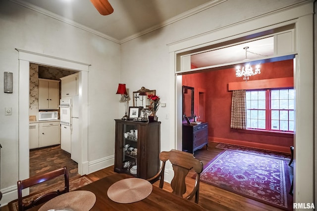 interior space with dark wood-type flooring, a notable chandelier, and ornamental molding