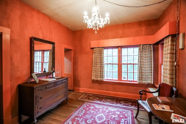 sitting room featuring a chandelier and wood-type flooring