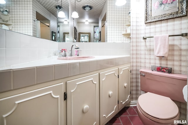 bathroom with toilet, tasteful backsplash, vanity, and tile patterned floors