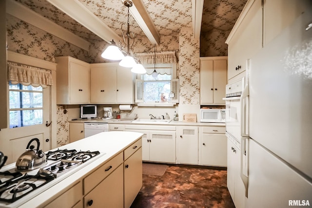 kitchen with white appliances, sink, and pendant lighting