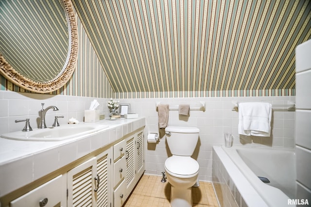 bathroom with toilet, tile patterned flooring, vanity, tile walls, and a bath