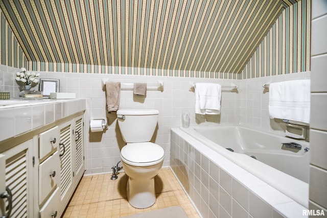 bathroom featuring tile walls, vanity, tiled tub, and toilet