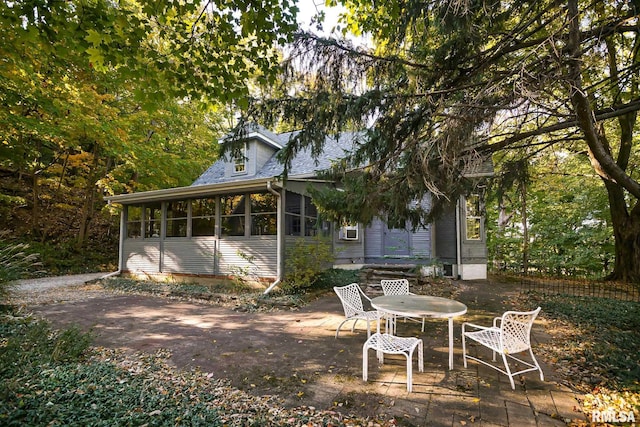 back of property with a patio area and a sunroom