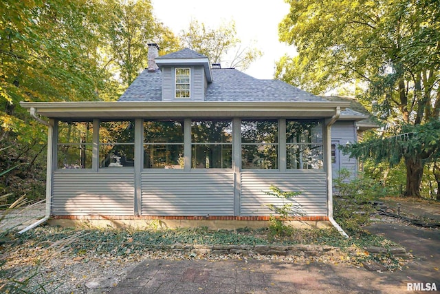 view of property exterior with a sunroom