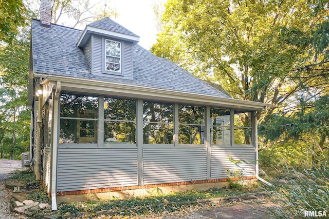 view of property exterior with a sunroom