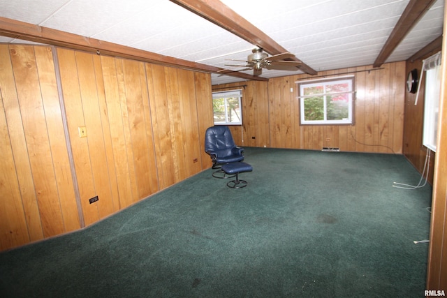 unfurnished room featuring wood walls, carpet, ceiling fan, and beam ceiling