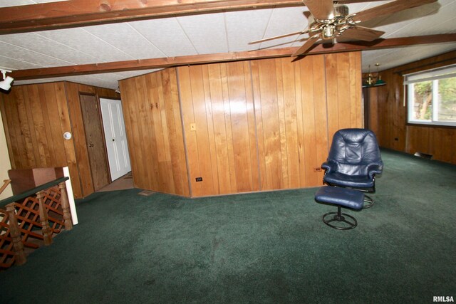 unfurnished room featuring carpet, wood walls, beamed ceiling, and ceiling fan