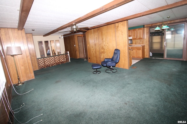 basement with dark colored carpet, wooden walls, and ceiling fan