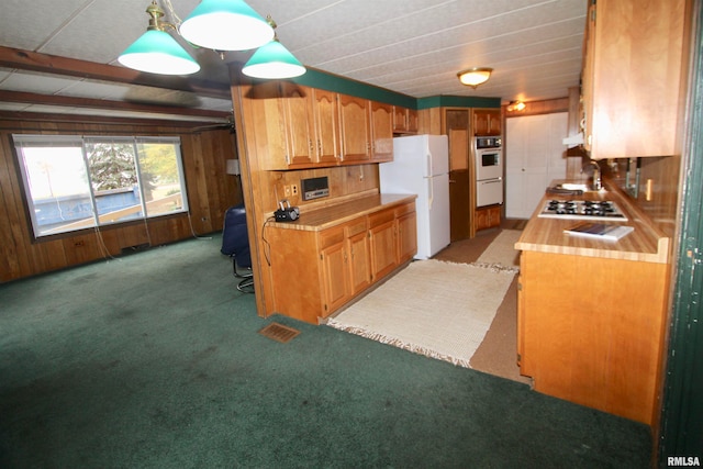 kitchen featuring light colored carpet, hanging light fixtures, sink, and white appliances