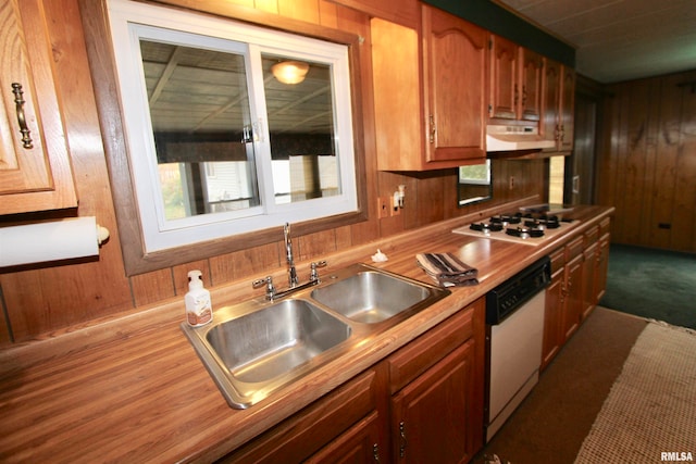 kitchen featuring white appliances, wooden walls, ventilation hood, and sink