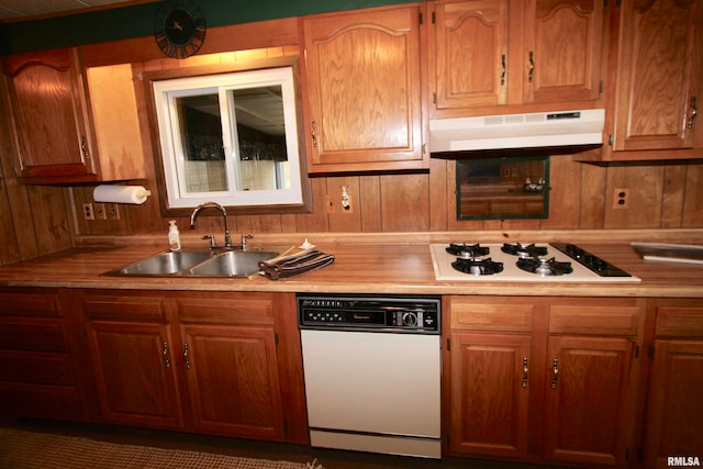 kitchen featuring wood walls, sink, and white appliances