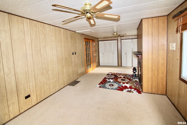 interior space featuring wooden walls and light carpet