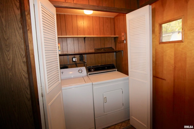 laundry area with washer and clothes dryer and wood walls