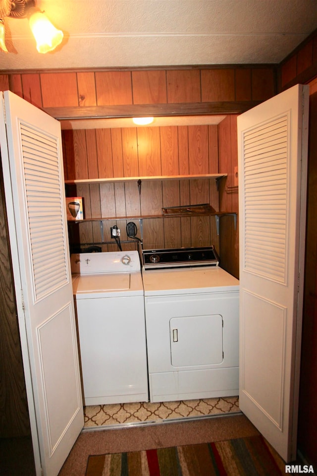 washroom with wood walls and washing machine and clothes dryer