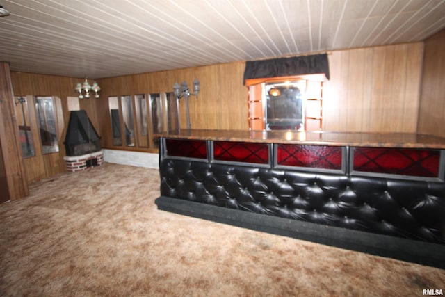 bedroom featuring carpet flooring, wooden walls, and an inviting chandelier