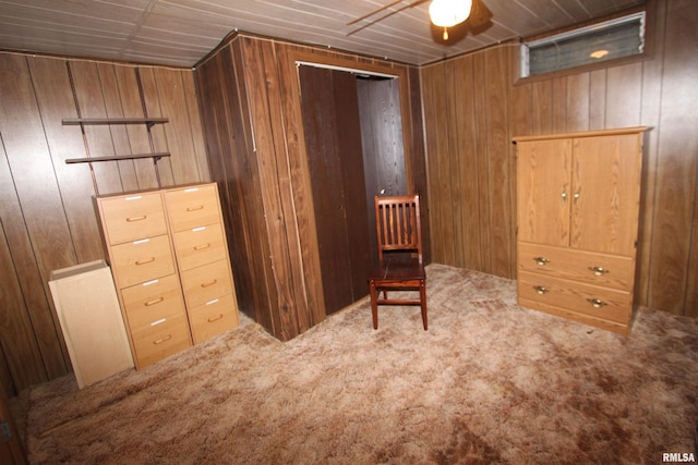 sitting room with wood walls, carpet flooring, ceiling fan, and wooden ceiling