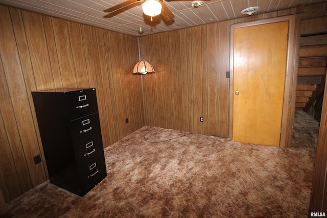 carpeted empty room featuring wood walls, ceiling fan, and wood ceiling