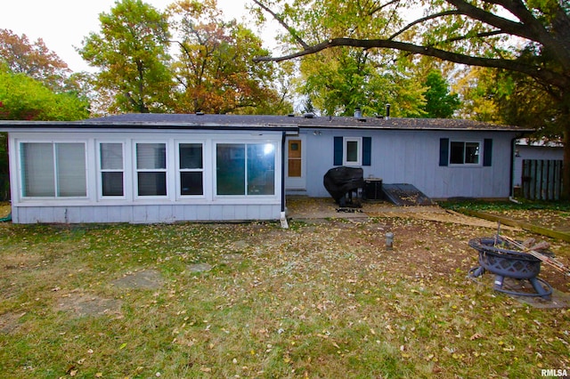 rear view of house featuring a yard and an outdoor fire pit