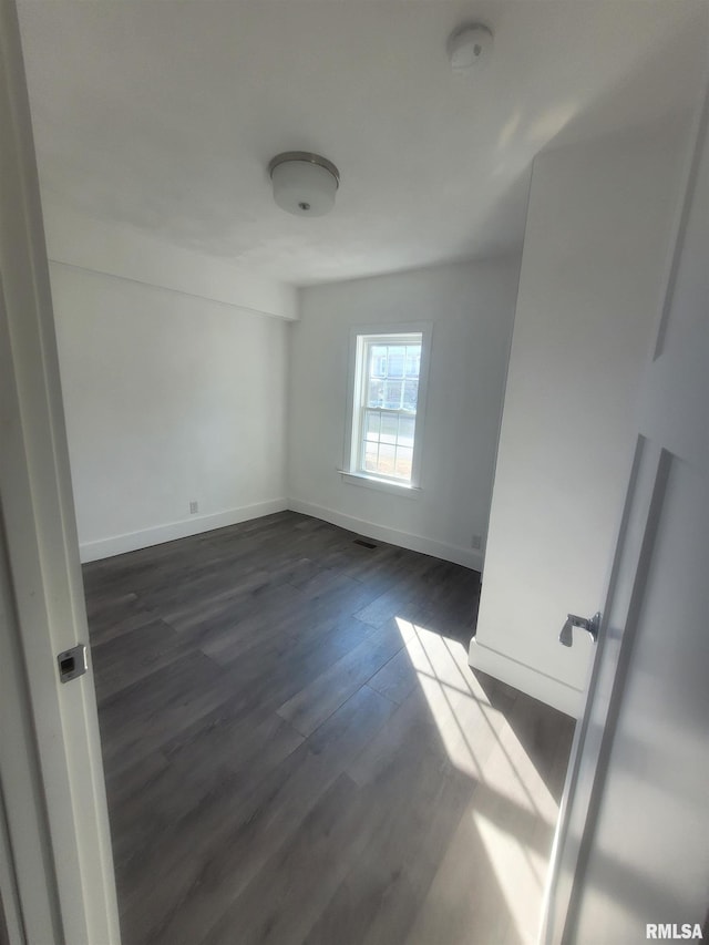 spare room with dark hardwood / wood-style flooring