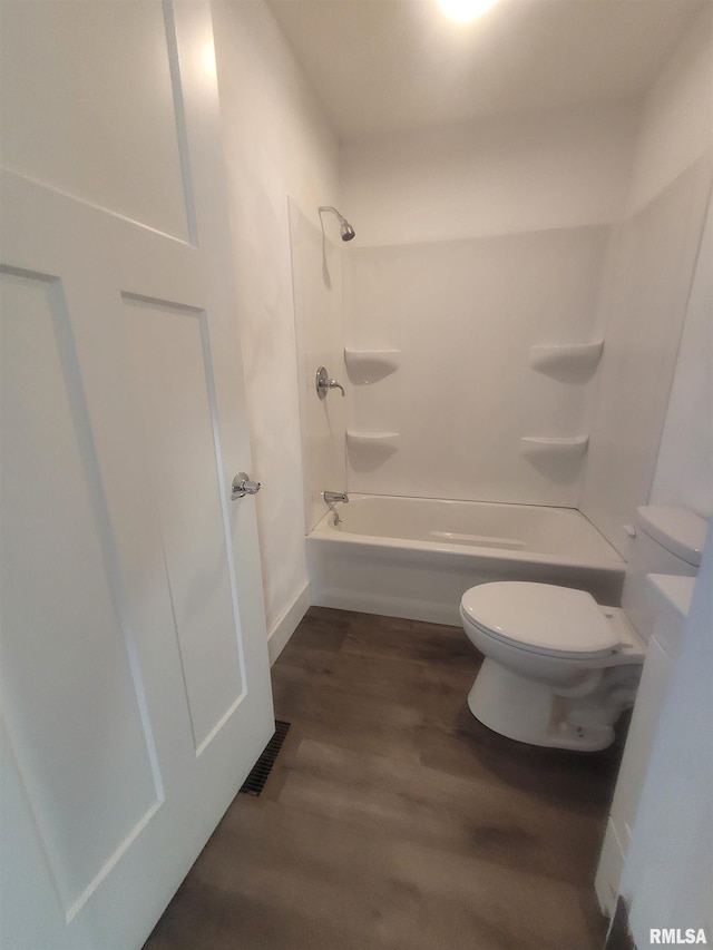 bathroom featuring shower / bathing tub combination, wood-type flooring, and toilet