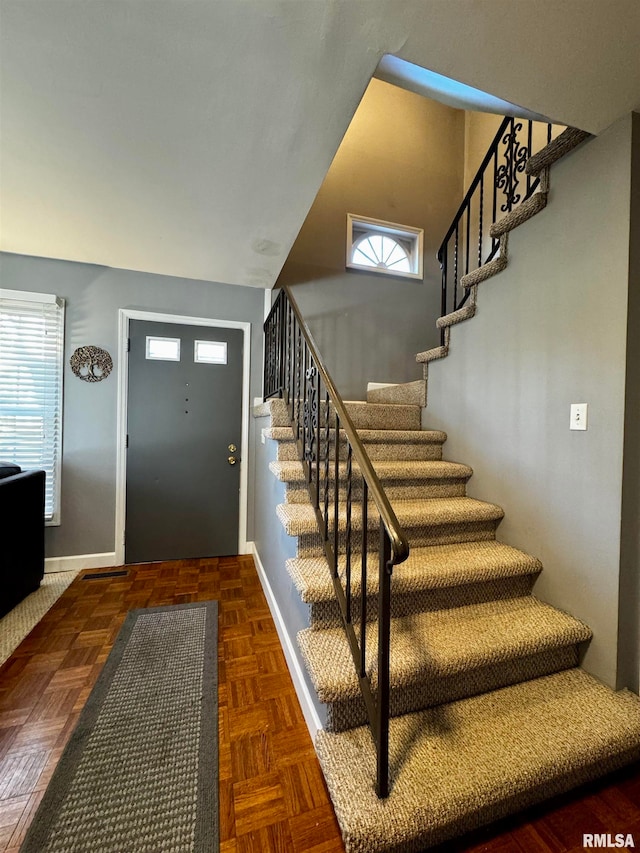 foyer entrance featuring a wealth of natural light and dark parquet floors