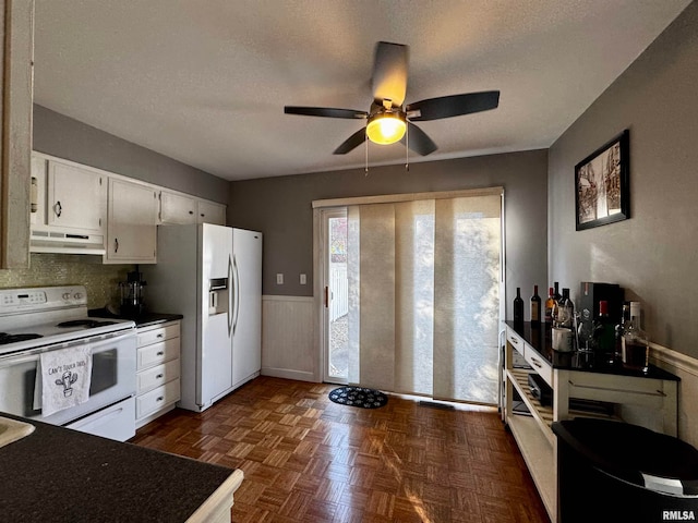 kitchen featuring white cabinets, a textured ceiling, white appliances, and ceiling fan