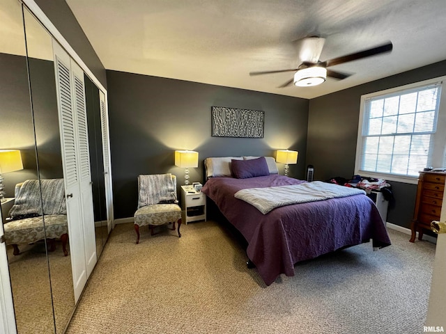 bedroom featuring ceiling fan, multiple closets, and light colored carpet