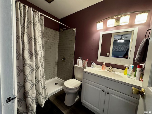 bathroom with toilet, wood-type flooring, curtained shower, vanity, and ceiling fan