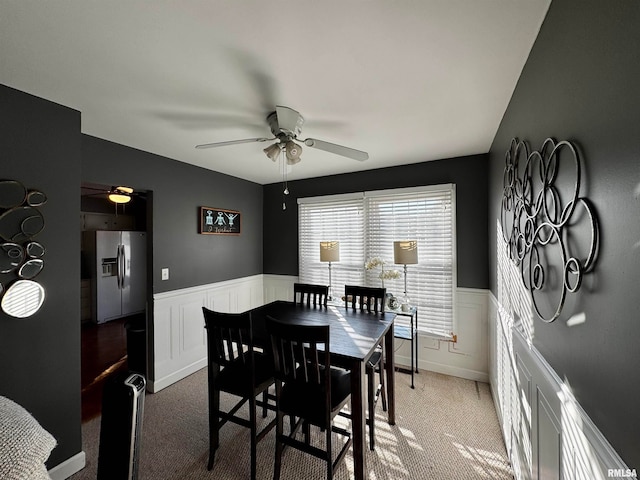 dining area featuring ceiling fan and light colored carpet