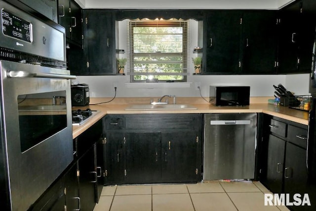 kitchen with black appliances, sink, and light tile patterned floors